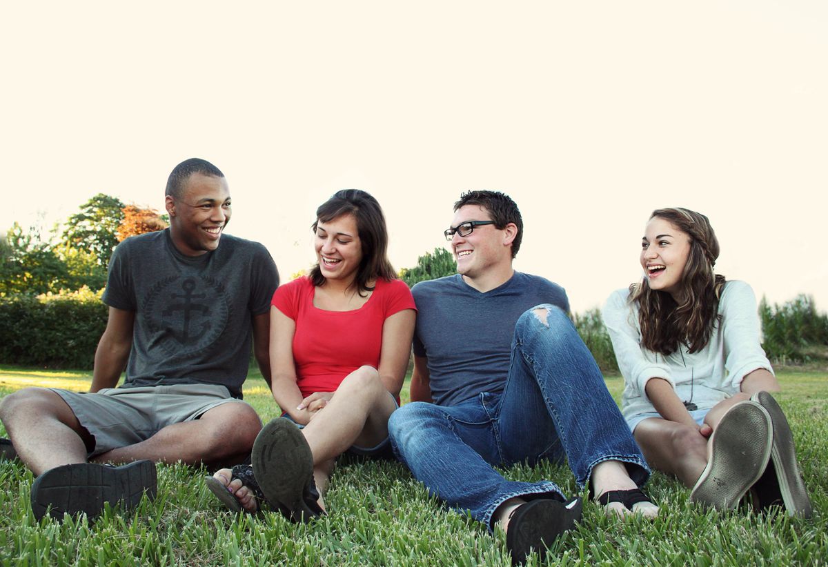 A diverse group of young adults together outdoors.