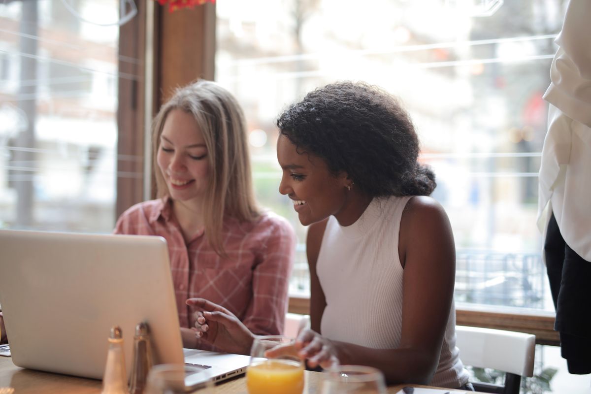 Two young people working together at a laptop.